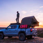 Man on top with installed Tent and Cali Raised Overland Bed Rack | 2005-2023 Toyota Tacoma